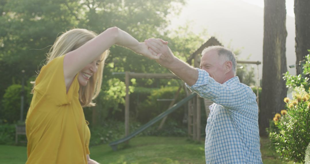 Joyful Father and Daughter Dancing in Sunlit Garden