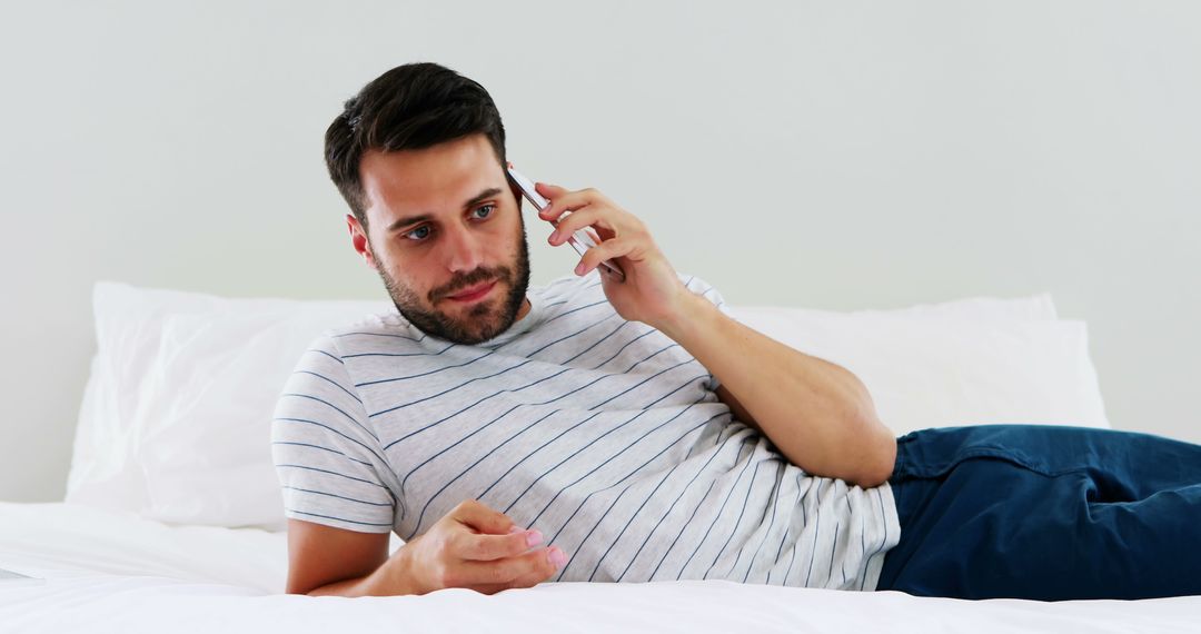 Young Man Relaxing on Bed While Talking on Phone - Free Images, Stock Photos and Pictures on Pikwizard.com