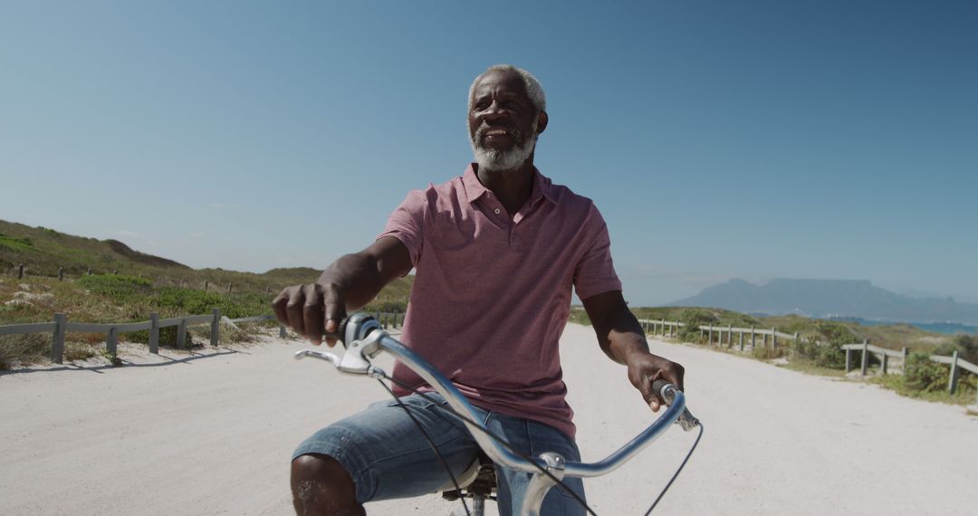 Senior Man Riding Bicycle on Beach Road, Enjoying Nature - Free Images, Stock Photos and Pictures on Pikwizard.com