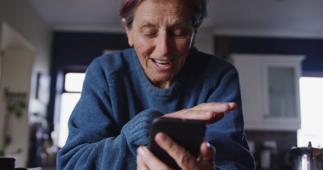 Senior Woman Using Smartphone at Home Smiling - Free Images, Stock Photos and Pictures on Pikwizard.com