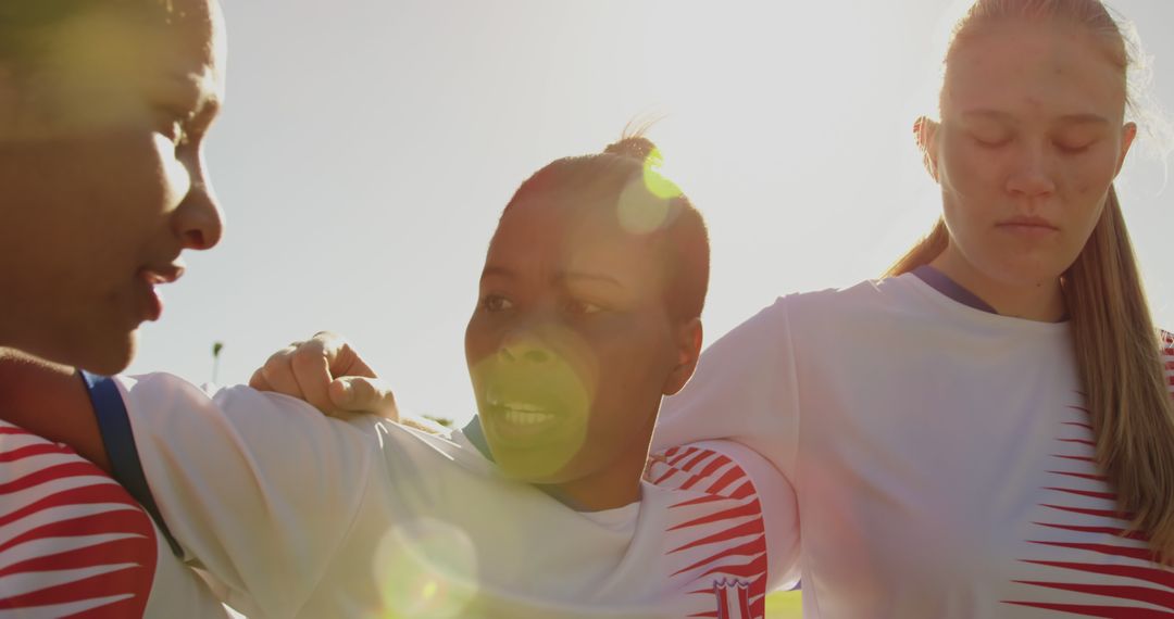 Female Soccer Team Embracing During Warm-Up with Sun Flare - Free Images, Stock Photos and Pictures on Pikwizard.com