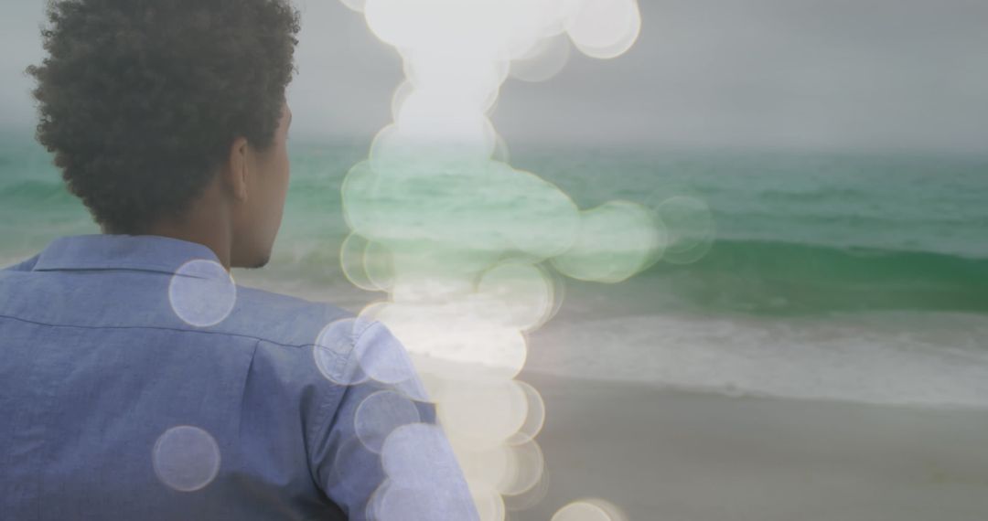 Contemplative Man by Ocean with Dreamy Light Effects