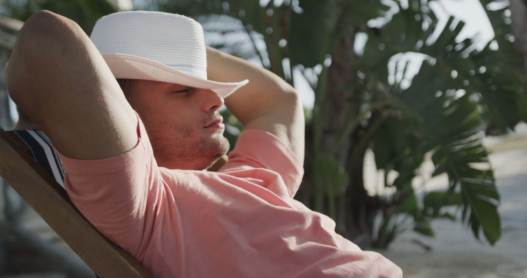 Relaxed Man Sitting on Chair Enjoying Tropical Paradise - Free Images, Stock Photos and Pictures on Pikwizard.com