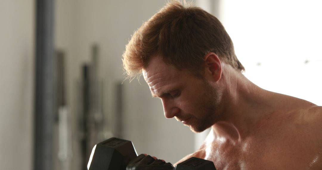 Focused Man Lifting Dumbbell in Gym - Free Images, Stock Photos and Pictures on Pikwizard.com