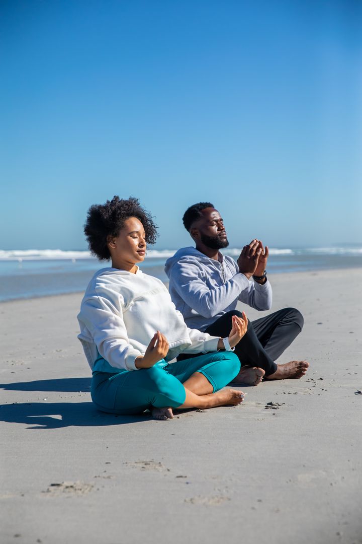 Couple Meditating on Tranquil Ocean Beach