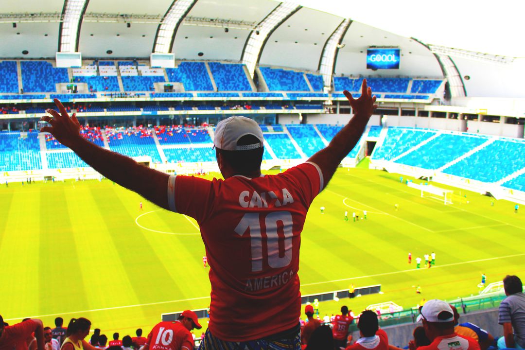 Stadium Fan Cheering With Arms Raised Watching Soccer Match From Upper Stands