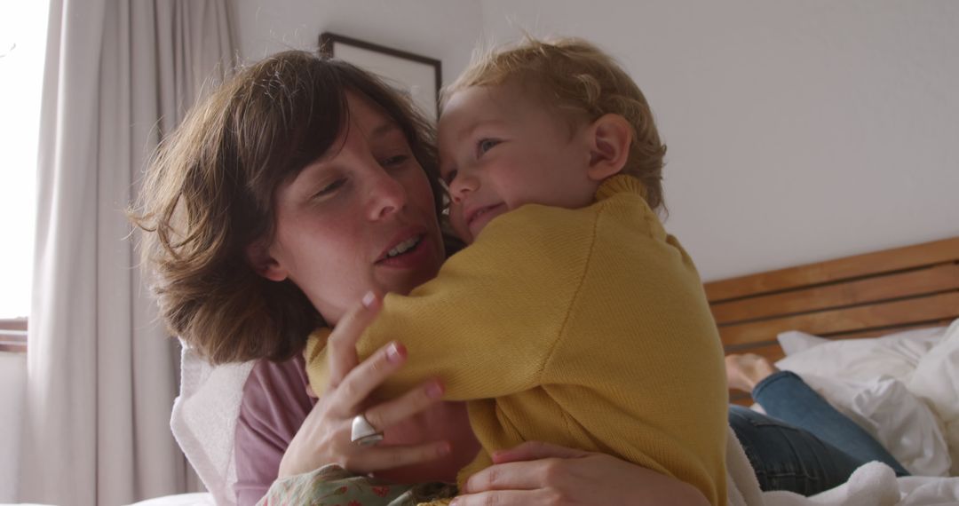 Mother Embracing Young Child in Cozy Bedroom - Free Images, Stock Photos and Pictures on Pikwizard.com