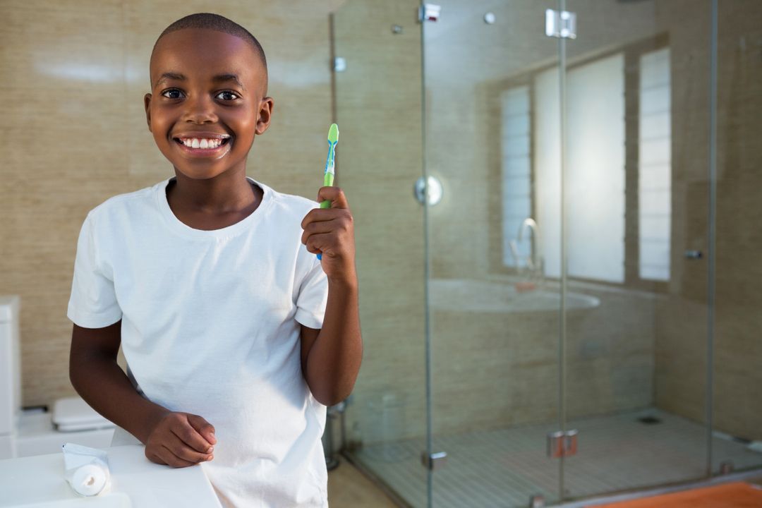 Smiling Boy Holding Toothbrush in Modern Bathroom - Free Images, Stock Photos and Pictures on Pikwizard.com
