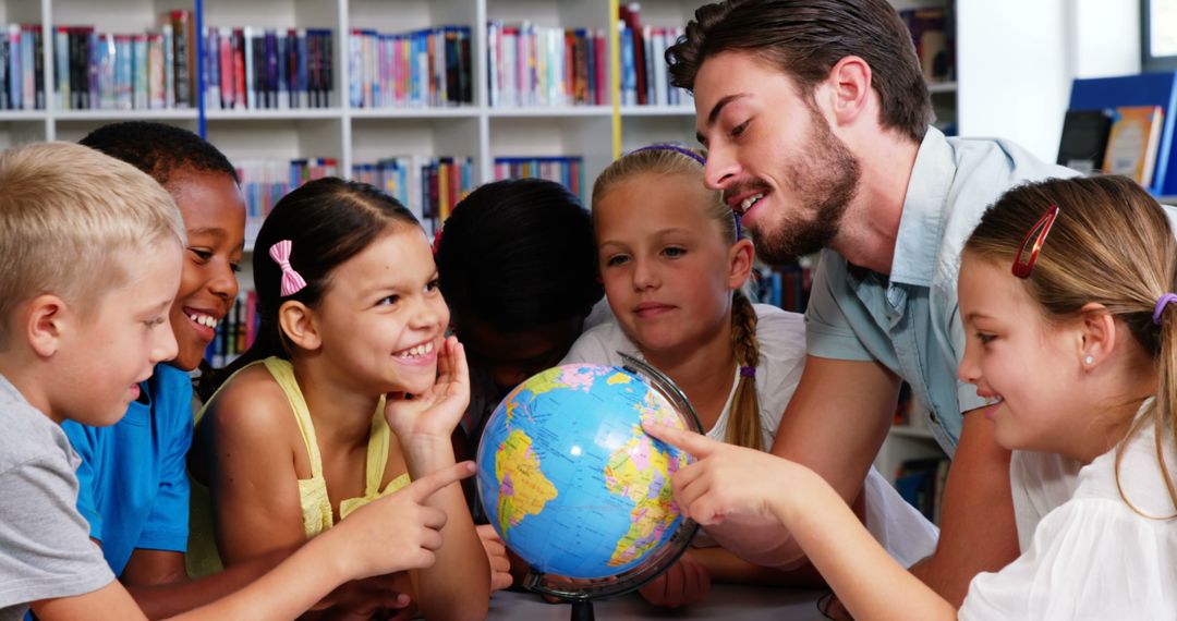 Young Teacher Helping Curious Students with Globe in Library - Free Images, Stock Photos and Pictures on Pikwizard.com