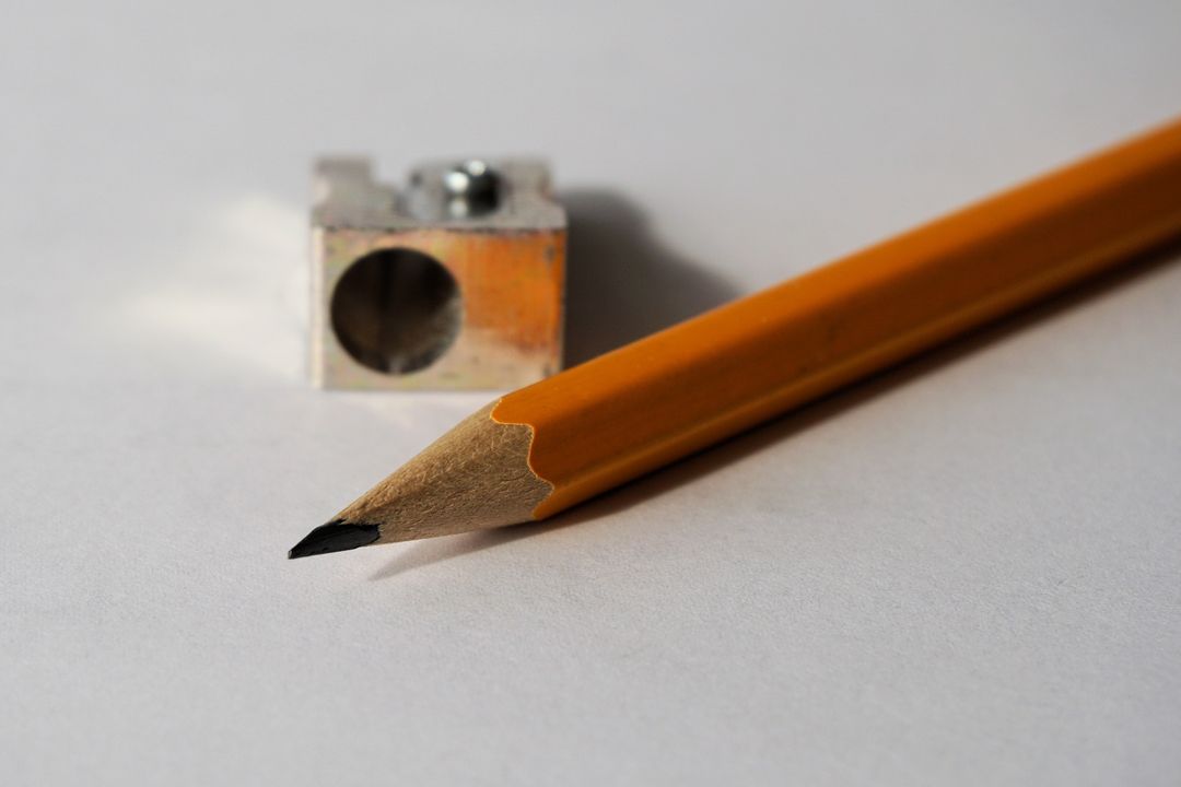 Close-Up of Sharp Orange Pencil and Sharpener on White Background - Free Images, Stock Photos and Pictures on Pikwizard.com