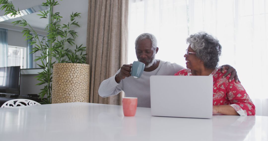 Elderly Couple Enjoying Morning Coffee and Laptop at Home - Free Images, Stock Photos and Pictures on Pikwizard.com