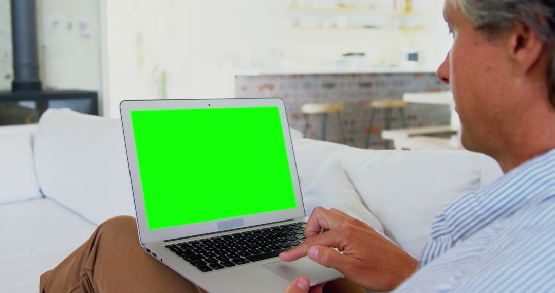 Man Using Laptop with Green Screen at Home in the Living Room - Free Images, Stock Photos and Pictures on Pikwizard.com