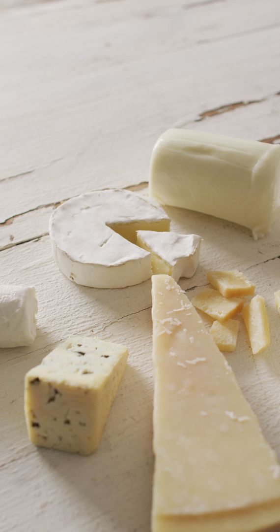 Assorted Artisan Cheeses on Rustic White Table