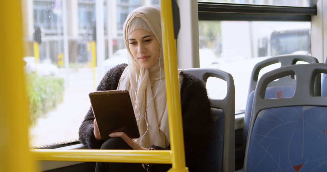 Young Muslim Woman Using Tablet on Bus - Free Images, Stock Photos and Pictures on Pikwizard.com