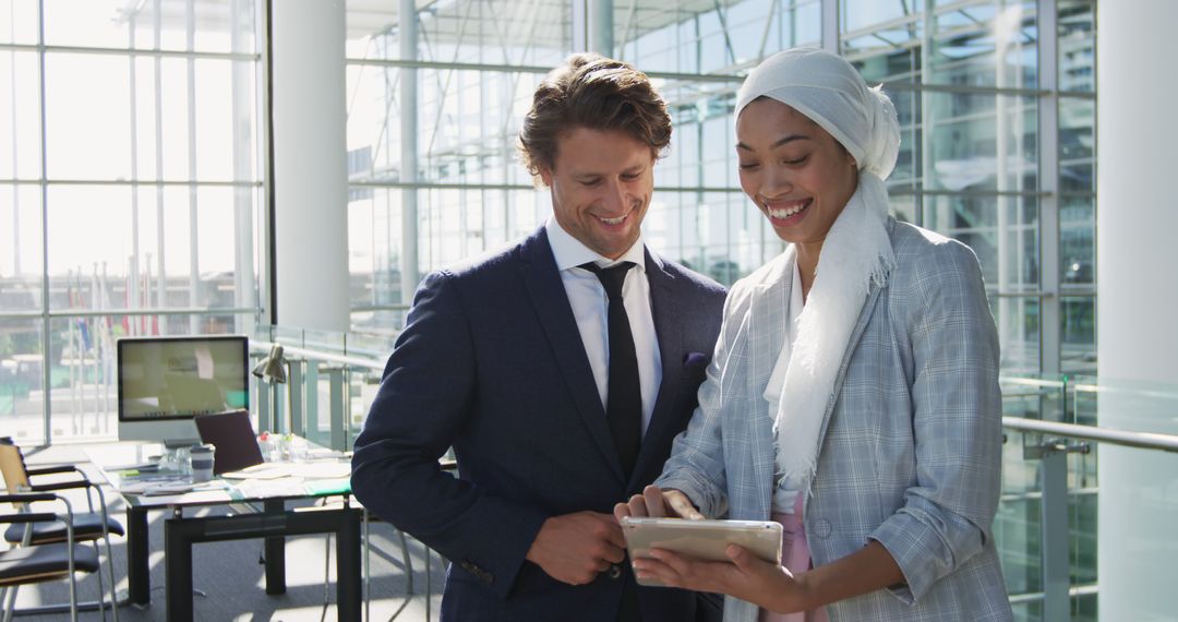 Diverse Entrepreneurs Collaborating with Tablet in Modern Office