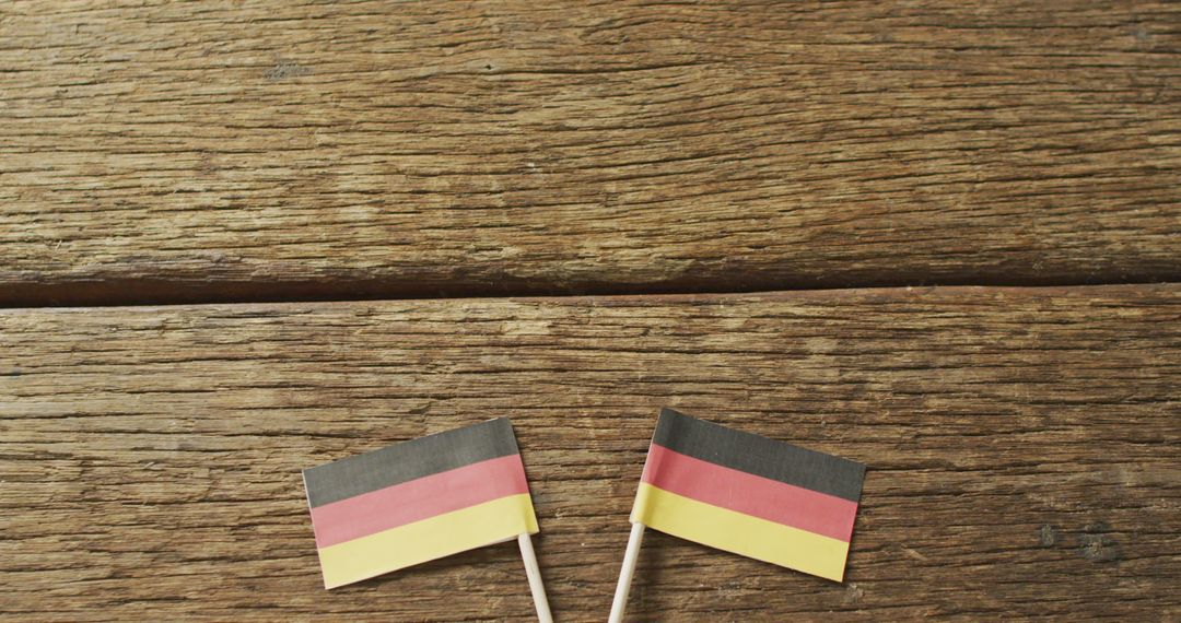 Two Small German Flags on Wooden Surface - Free Images, Stock Photos and Pictures on Pikwizard.com