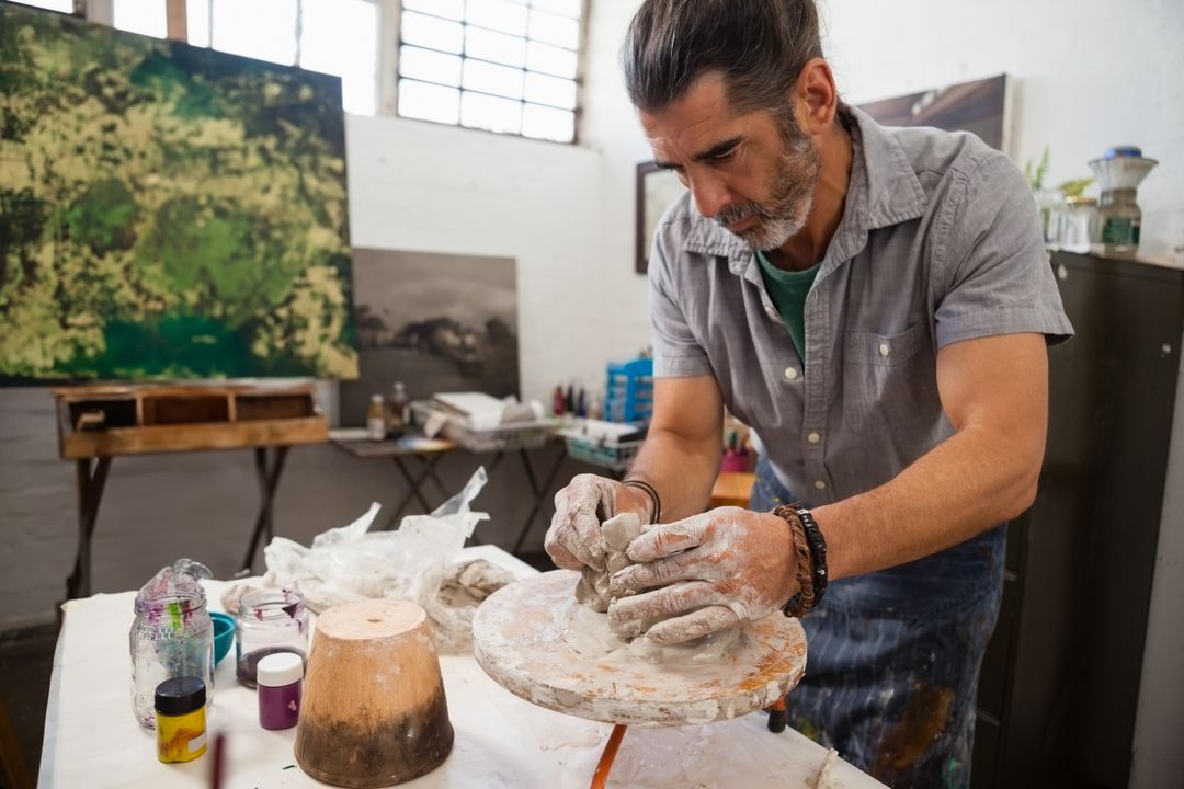 Middle-Aged Sculptor Shaping Clay at Studio Workspace
