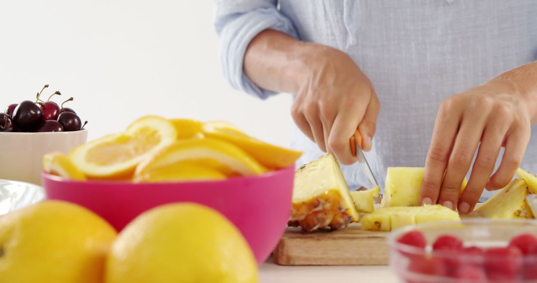 Person Slicing Pineapple with Bowls of Fruit - Free Images, Stock Photos and Pictures on Pikwizard.com