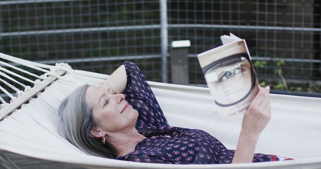 Senior Woman Relaxing in Hammock Reading Book - Free Images, Stock Photos and Pictures on Pikwizard.com