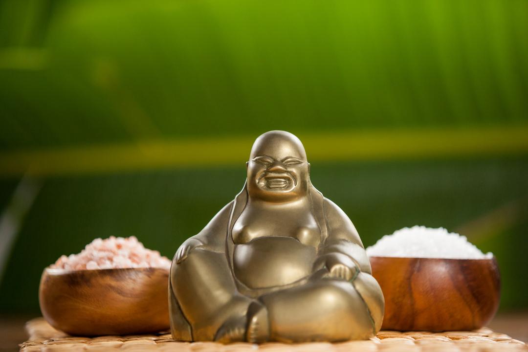 Laughing buddha figurine and sea salt in wooden bowl - Free Images, Stock Photos and Pictures on Pikwizard.com