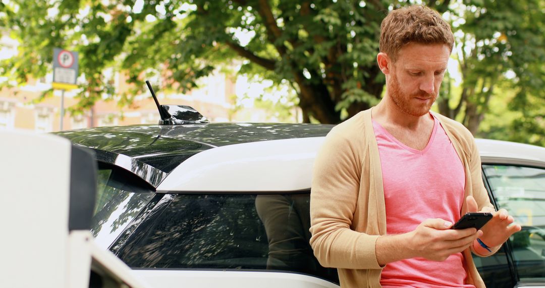 Man using smartphone while standing near car outdoors - Free Images, Stock Photos and Pictures on Pikwizard.com