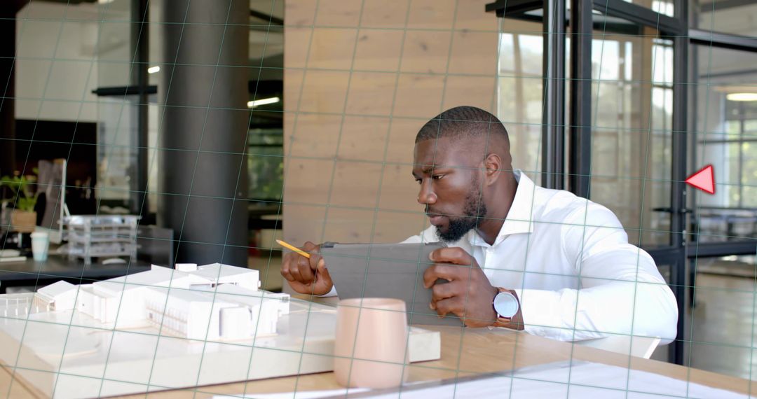 Architect Analyzing Scale Model with Tablet in Modern Workspace