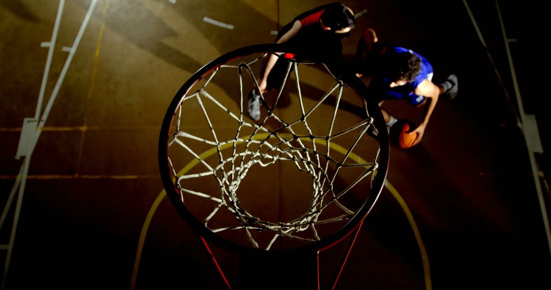 Top view of basketball players competing during night game - Free Images, Stock Photos and Pictures on Pikwizard.com