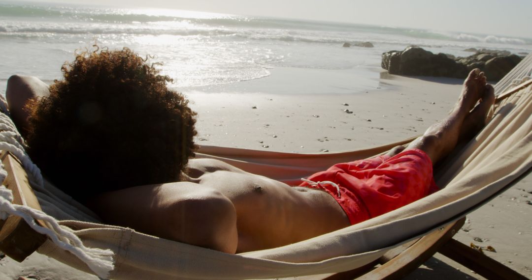 Man Relaxing in Hammock on Beach by Ocean Waves - Free Images, Stock Photos and Pictures on Pikwizard.com