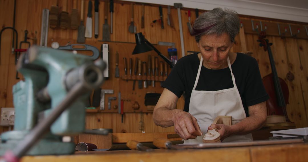 Senior Woman Carving Wood in Workshop - Free Images, Stock Photos and Pictures on Pikwizard.com