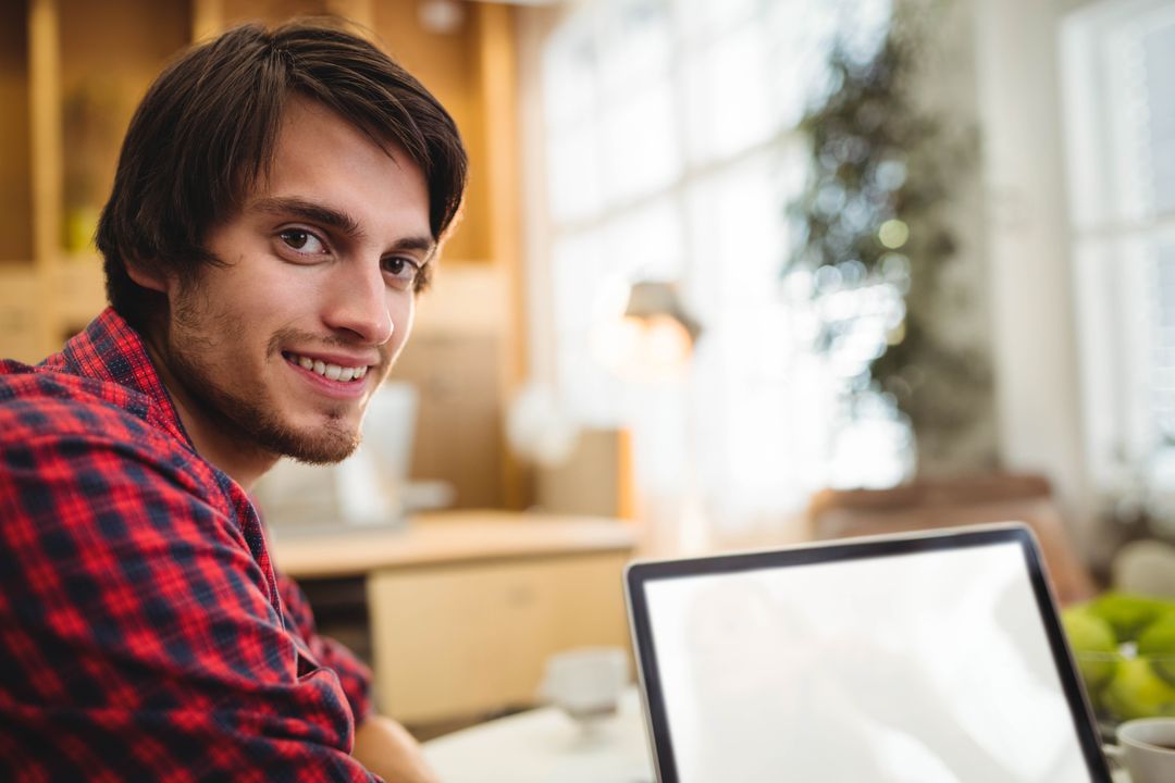 Young Professional Using Laptop in Cozy Home Workspace