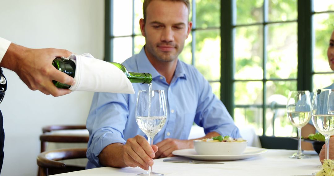 Man Dining at Upscale Restaurant Being Served Wine - Free Images, Stock Photos and Pictures on Pikwizard.com