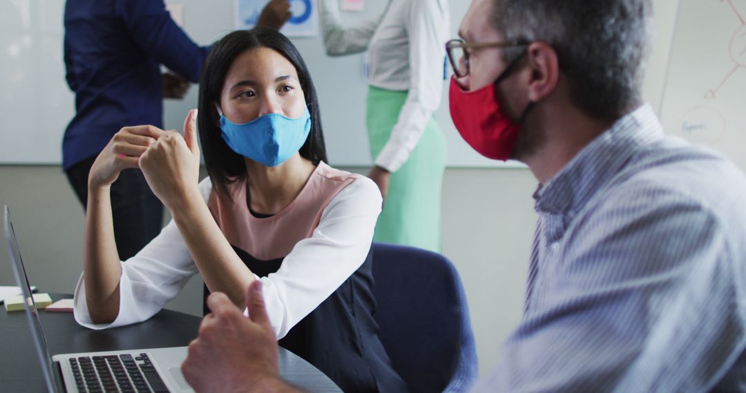 Office Colleagues Discussing Work Wearing Face Masks - Free Images, Stock Photos and Pictures on Pikwizard.com