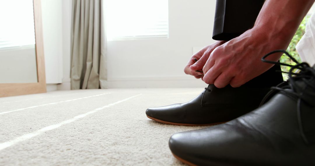 Close-up of Man Tying Black Dress Shoes on Carpeted Floor - Free Images, Stock Photos and Pictures on Pikwizard.com