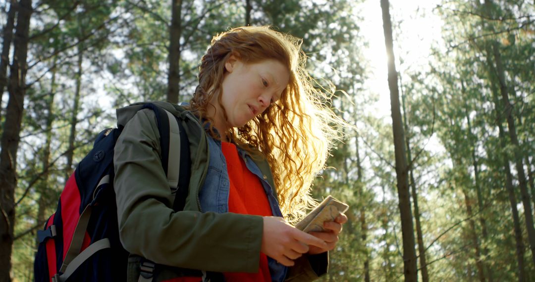 Woman Navigating Forest Path with Mobile Device