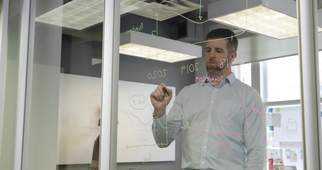 Business Professional Analyzing Data on Glass Partition