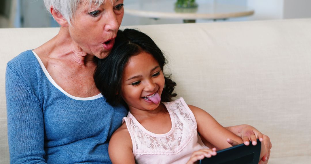 Grandmother and Granddaughter Having Fun with Tablet - Free Images, Stock Photos and Pictures on Pikwizard.com