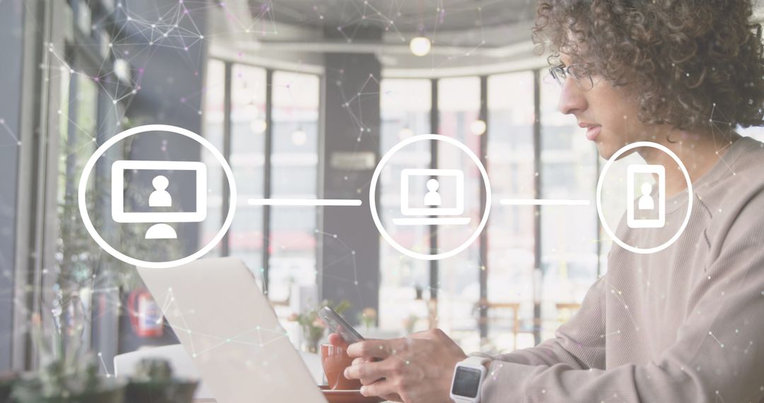 Tech-Savvy Individual Using Smartphone and Laptop in Modern Cafe