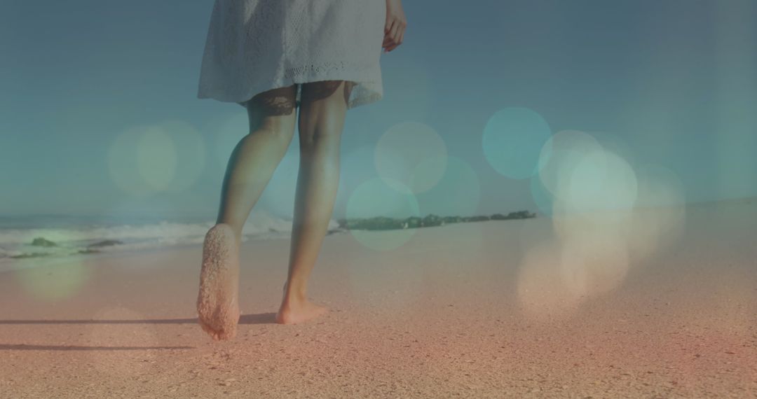 Woman's Barefoot Walk on Sunny Beach with Artistic Lens Flare