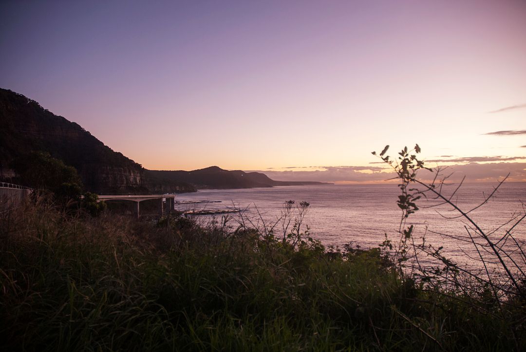 Scenic Coastal Sunset with Soft Purple Sky and Cliffside View - Free Images, Stock Photos and Pictures on Pikwizard.com