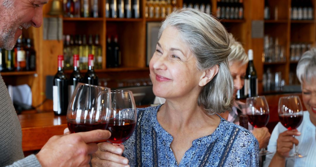 Smiling Woman Toasting with Red Wine at a Social Gathering