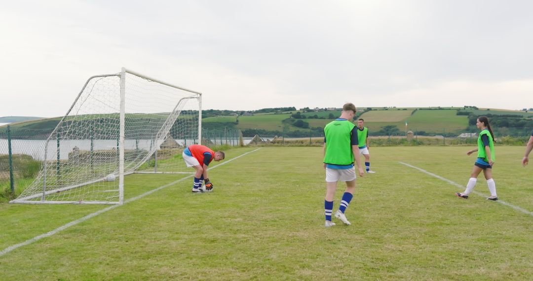 Soccer Players Practicing on Scenic Field with Goalkeeper