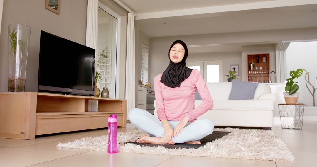 Muslim Woman Meditating at Home in Casual Clothes - Free Images, Stock Photos and Pictures on Pikwizard.com