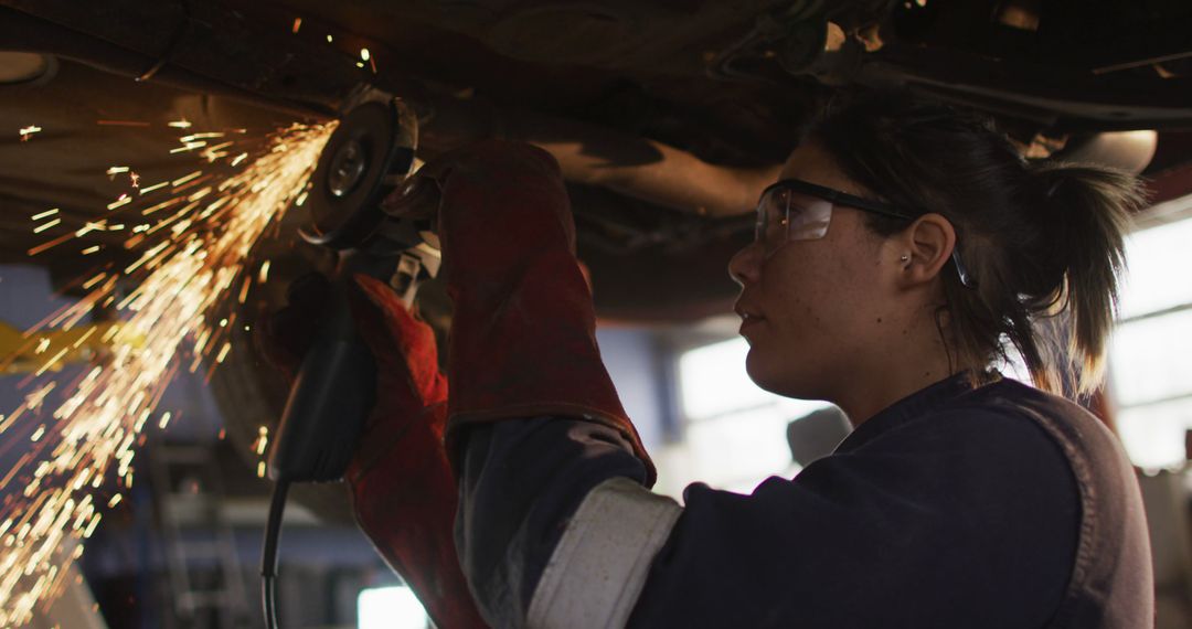 Female Auto Mechanic Using Grinder with Sparks Flying in Workshop - Free Images, Stock Photos and Pictures on Pikwizard.com