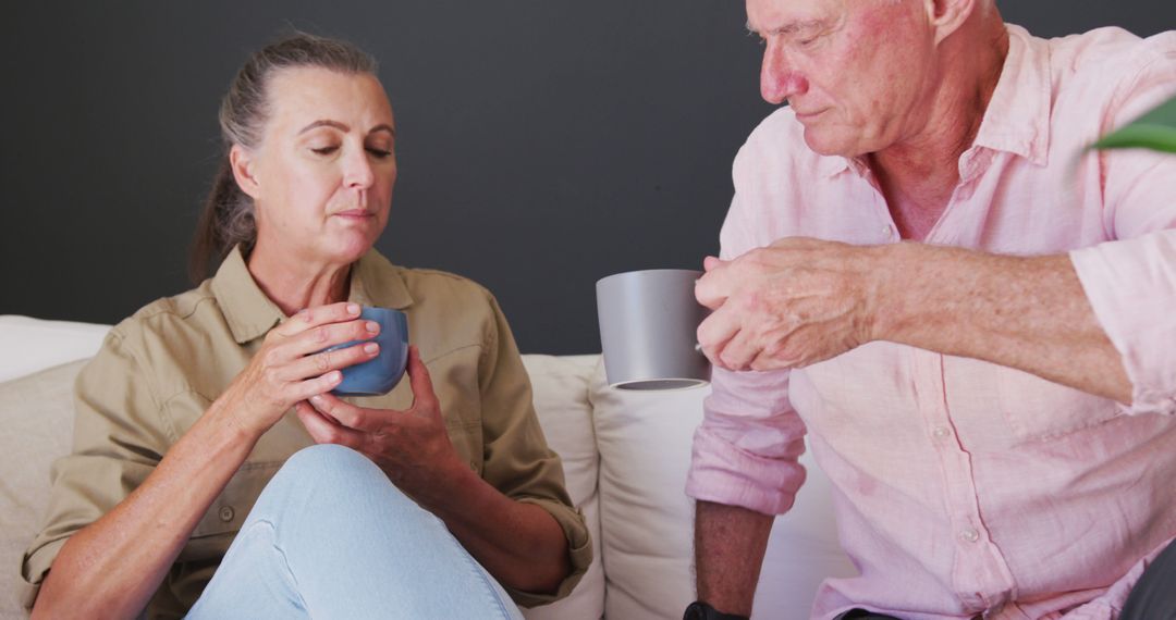 Senior Couple Enjoying Coffee and Conversation on Couch