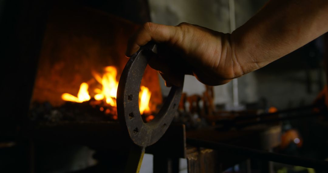 Blacksmith Holding Horseshoe with Fire in Forge - Free Images, Stock Photos and Pictures on Pikwizard.com