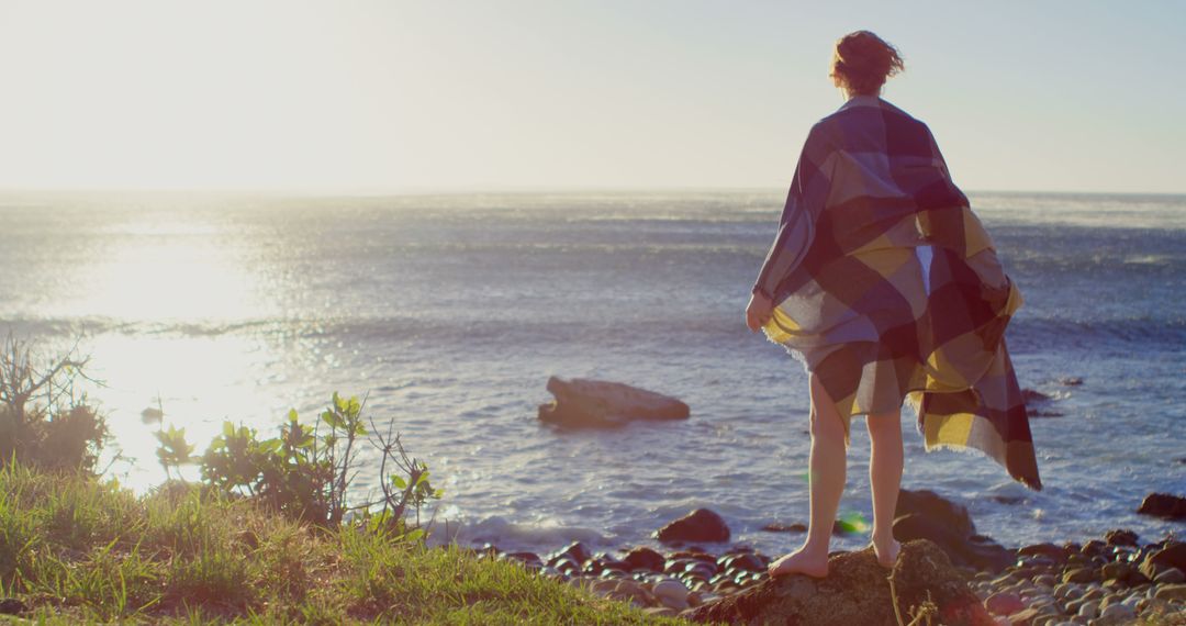 Person Wrapped in Blanket Enjoying Ocean View at Sunset - Free Images, Stock Photos and Pictures on Pikwizard.com