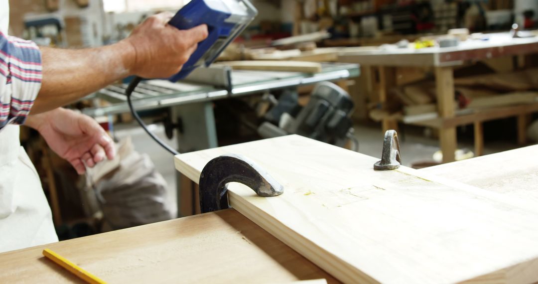 Carpenter using leveling tool on wooden plank in workshop - Free Images, Stock Photos and Pictures on Pikwizard.com