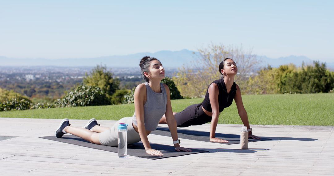 Diverse Female Friends Practicing Yoga Outdoors with Water Bottles