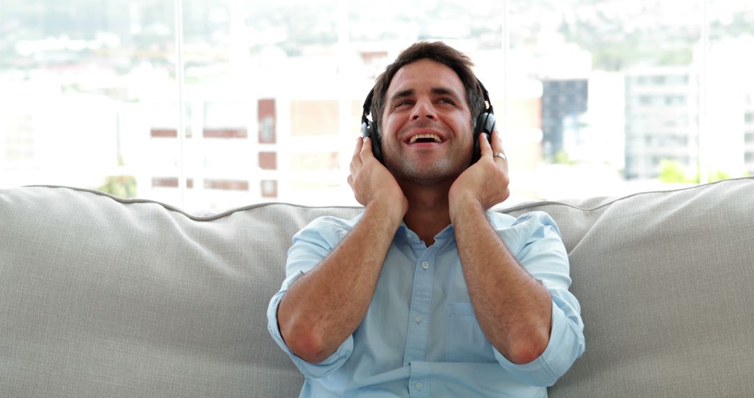 Joyful Man Relaxing with Headphones on Sofa at Home - Free Images, Stock Photos and Pictures on Pikwizard.com