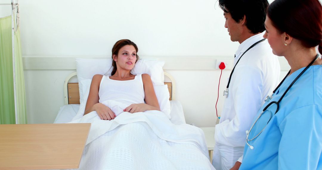 Medical Team Consulting Female Patient in Hospital Bed - Free Images, Stock Photos and Pictures on Pikwizard.com